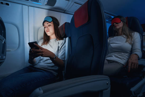 istock Female passenger typing on smartphone during night flight 1357625034