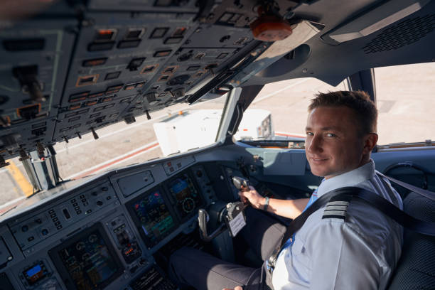 istock Smiling pilot posing for photo in cockpit 1357625056