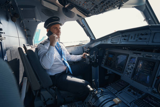 istock Plane captain talking on the phone in cockpit 1357625068