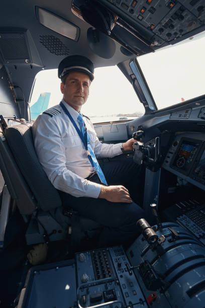 istock Plane captain staring to side from his seat in cockpit 1357625069