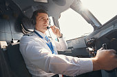 Male airplane captain speaking to ground control through microphone