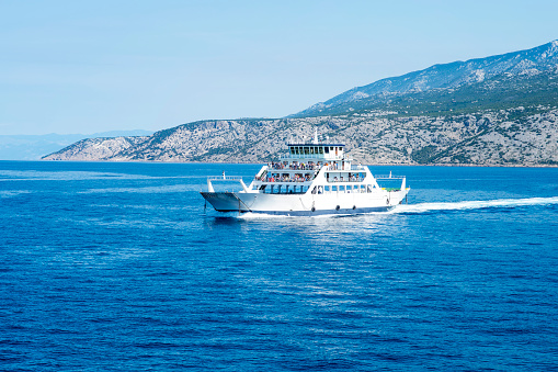 Car ferry boat in Croatia linking the island Rab to mainland passing by on adriatic sea.