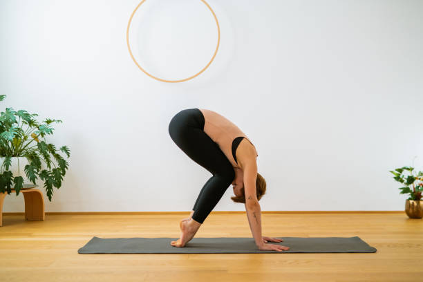 istock Woman Holding Standing Forward Fold Pose With Knees Bent 1357626842