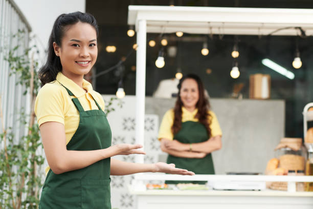 istock Young Woman Welcoming Customers 1357628467