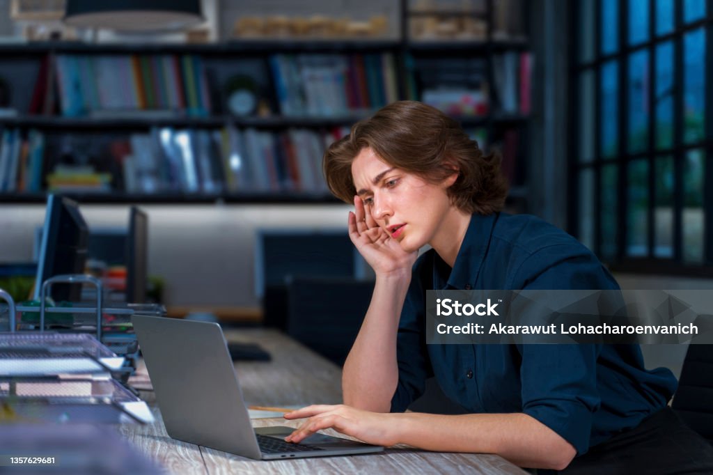Caucasian young businesswoman is working hard overtime at late night to meet the task deadline with serious face and headache for business and education  concept Caucasian young businesswoman is working hard overtime at late night to meet the task deadline with serious face and headache for business and education Dissertation Stock Photo
