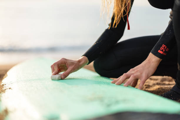 Portrait of a beautiful surfer woman in late 20s making preparation for a surf session at Barceloneta Beach, Spain.