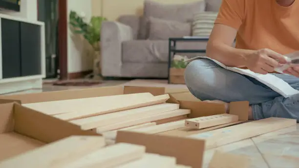 Asian man doing furniture Assemble in the living room  at home. Day time