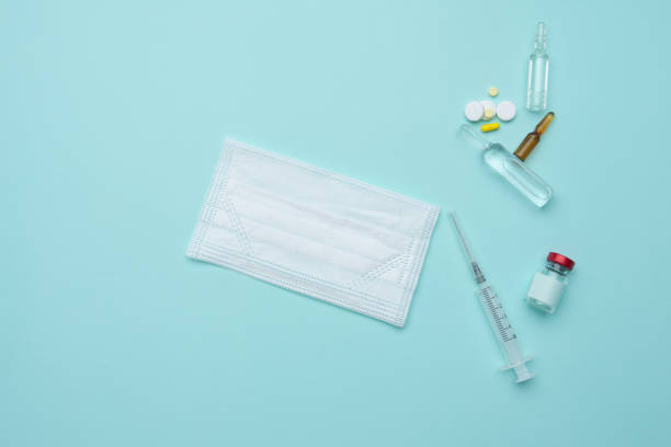 istock Syringe, mask, ampoules on a blue background, vaccination concept. 1357631243