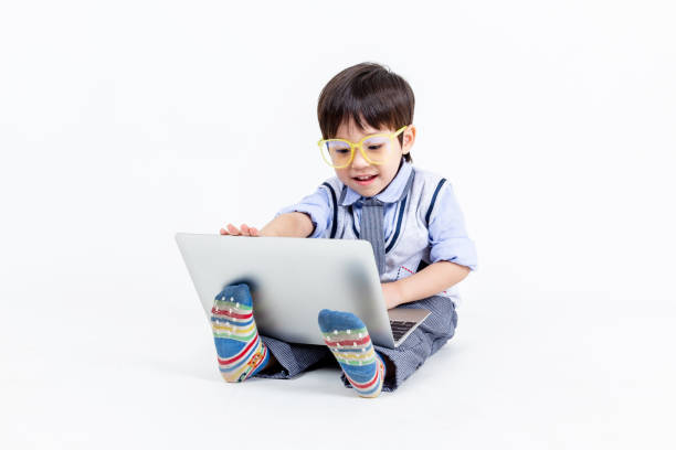 Cartoon Little Boy Teen Person Character Mascot with Colorful Children Wooden Toy Locomotive Train Invites to Play Through Laptop Screen on a white background. 3d Rendering