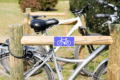 wooden bicycle parking in the street with blue sign