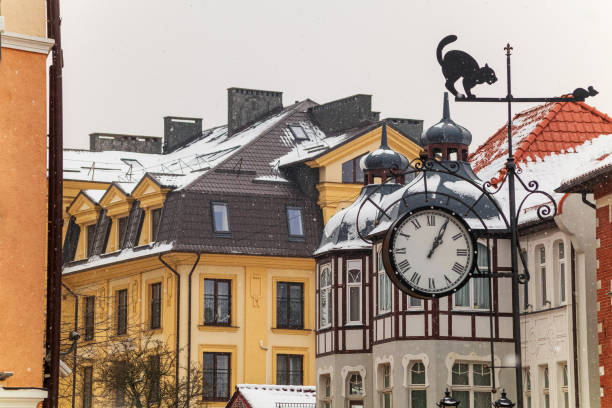 오래된 집, 거리 시계 및 고양이의 그림과 날씨 베인의 배경에 떨어지는 눈 - kaliningrad 뉴스 사진 이미지