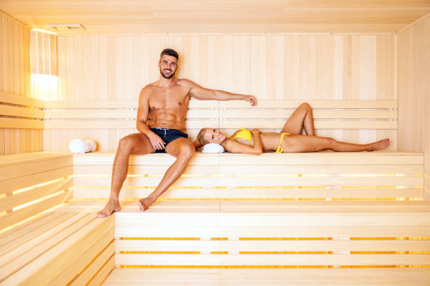 a happily married couple enjoys a weekend out of town. they choosing a spa to relax and refresh. a couple in a hot sauna - health spa spa treatment couple heterosexual couple imagens e fotografias de stock