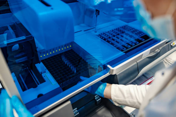 istock Science and vaccine discovery. A scientist putting vaccine samples to a test. A scientist putting test tubes in a machine. 1357642317