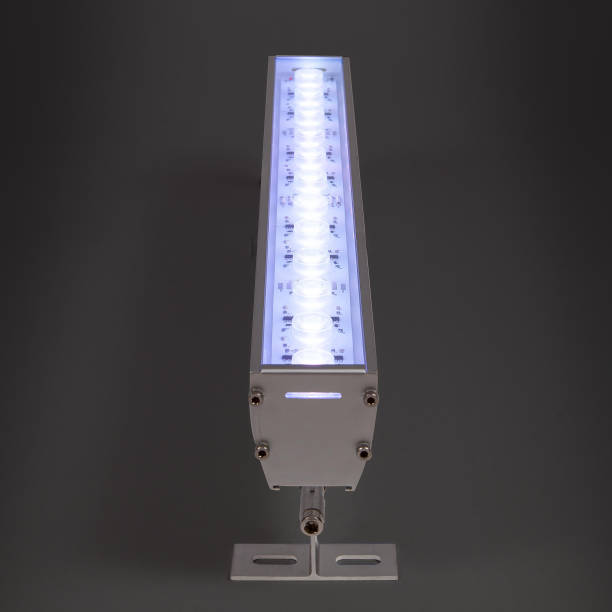 istock Blue LED flood light in aluminum housing with wire on dark background 1357643142