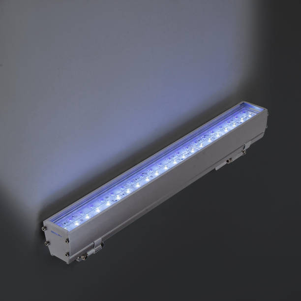 istock Blue LED flood light in aluminum housing with wire on dark background 1357643190