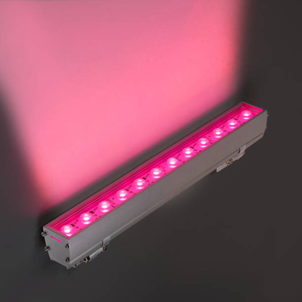 istock Red LED flood light in aluminum housing with wire on dark background 1357643698