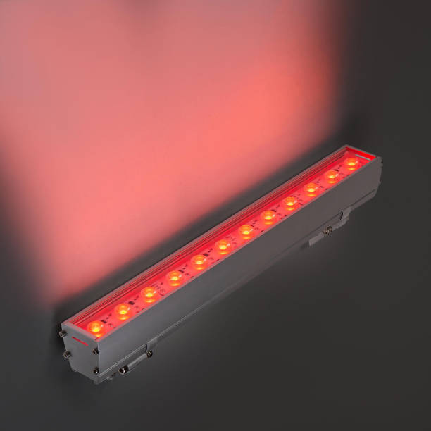 istock Red LED flood light in aluminum housing with wire on dark background 1357643717