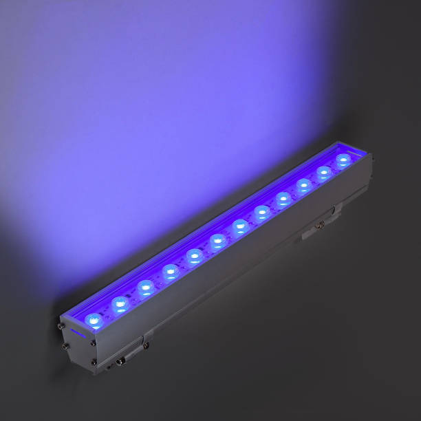 istock Blue LED flood light in aluminum housing with wire on dark background 1357643723