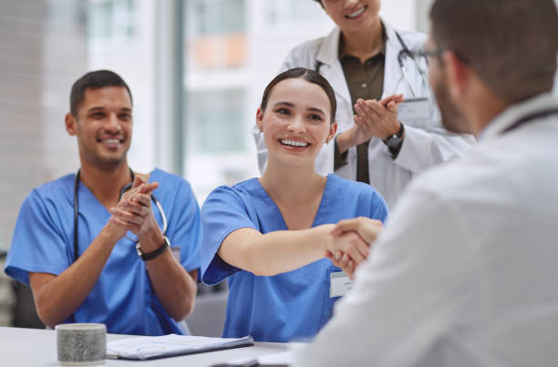 foto de un grupo de médicos dándose la mano y aplaudiendo durante una reunión en la sala de juntas de un hospital - board room discussion contract agreement fotografías e imágenes de stock