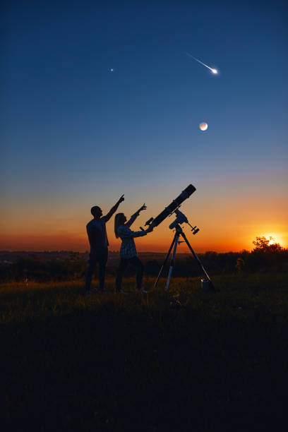 istock Couple stargazing together with a astronomical telescope. 1357645800