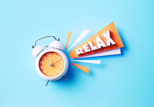 istock Relax Reads Next To A White Alarm Clock On Blue Background 1357645968