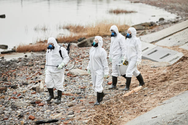 lavoratori in hazmat suits presso il sito del disastro ecologico - radiation protection suit clean suit toxic waste biochemical warfare foto e immagini stock