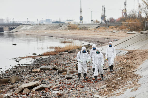 istock Group of Workers in Hazmat Suits at Industrial Disaster Site 1357646731