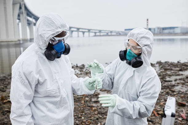 dois cientistas trabalhando ao ar livre - radiation protection suit clean suit toxic waste biochemical warfare - fotografias e filmes do acervo