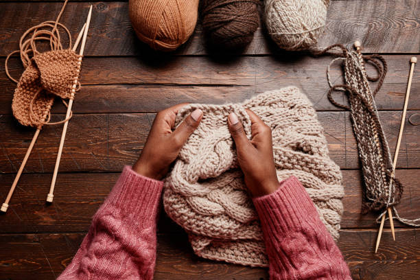 istock Female Hands Knitting on Wood 1357647085