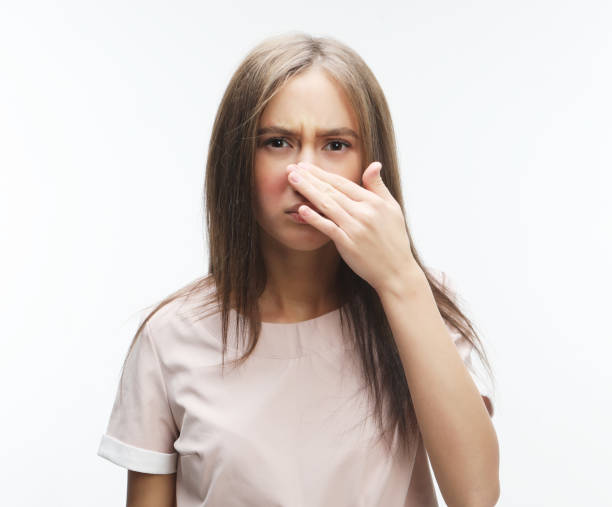 istock The stench. Closes the woman's nose 1357647535