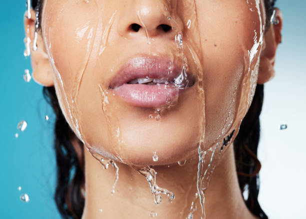 istock Cropped shot of an unrecognisable woman posing against a blue background while taking a shower 1357650077