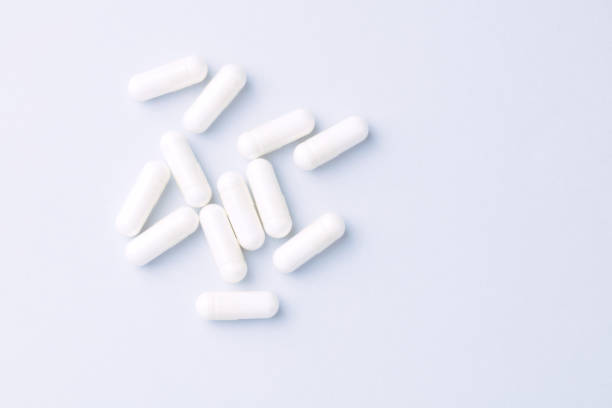 istock Arginine capsules. Bright paper background. Top view. Copy space. 1357651026