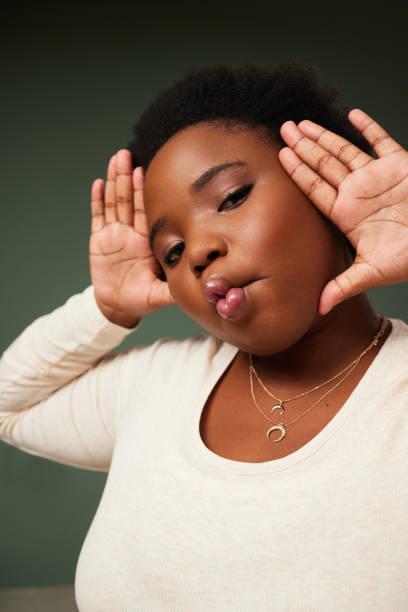 istock Shot of an attractive young woman pulling a funny face while posing against a green background in the studio 1357651592