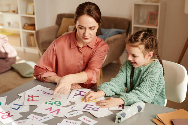 istock Girl learning English together with teacher 1357653724
