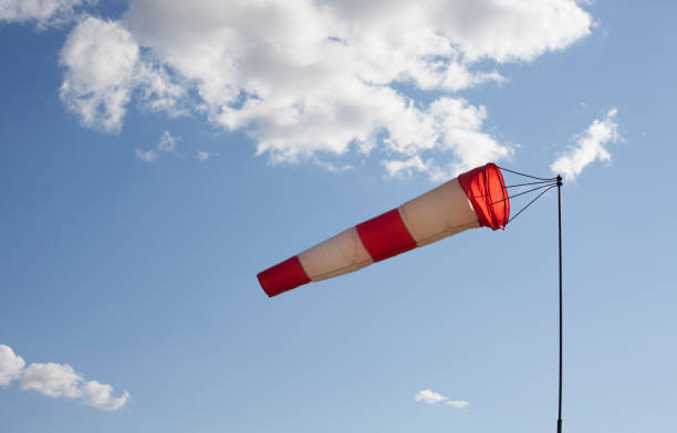 istock White and red wind flag (windsock) on a very sunny day with clouds. 1357653864