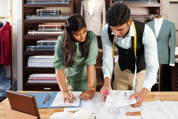 istock Tailors discussing fashion drawings 1357654059