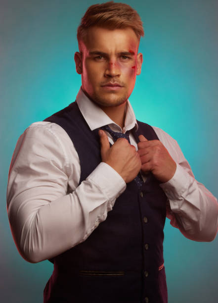 shot of a handsome young man standing alone in the studio and posing with a bruised face - aggression control clothing image type imagens e fotografias de stock