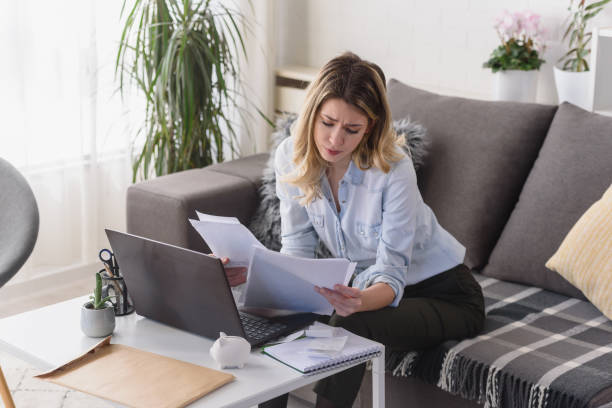 istock Young beautiful woman working on a computer at home, calculating monthly exspences, doing home budgeting 1357656745