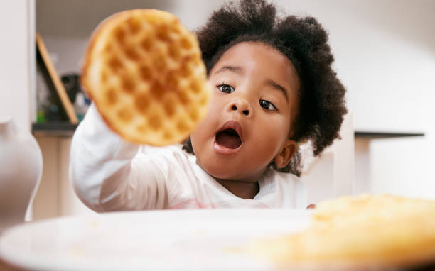 shot of a little girl about to eat a waffle - waffle breakfast food sweet food imagens e fotografias de stock