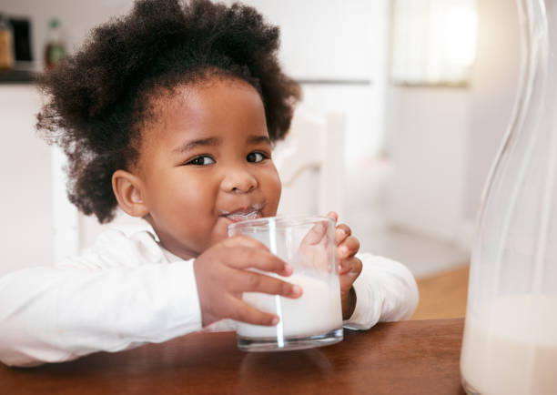 photo d’une petite fille dégustant un verre de lait - milk child drinking little girls photos et images de collection