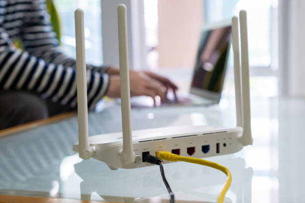 istock Selective focus at Lan cable socket of the router with people hand plug the fiber cable into internet router.  High speed internet for personal use with computer and technology. 1357657968