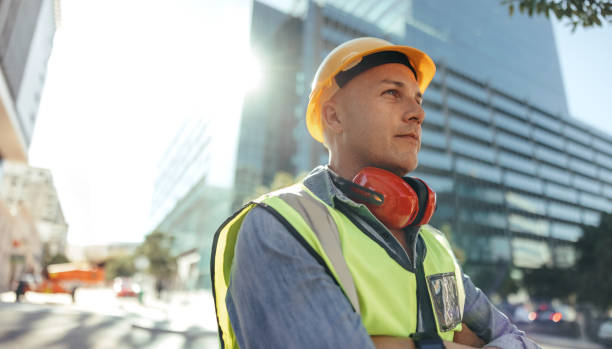 istock Thoughtful workman standing in the city 1357658429