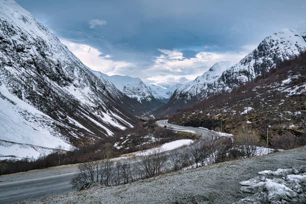 istock road over a pass in norway, between mountains and snow. 1357658444