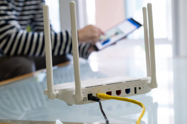 istock Selective focus at Lan cable socket of the router with people hand plug the fiber cable into internet router.  High speed internet for personal use with computer and technology. 1357659832