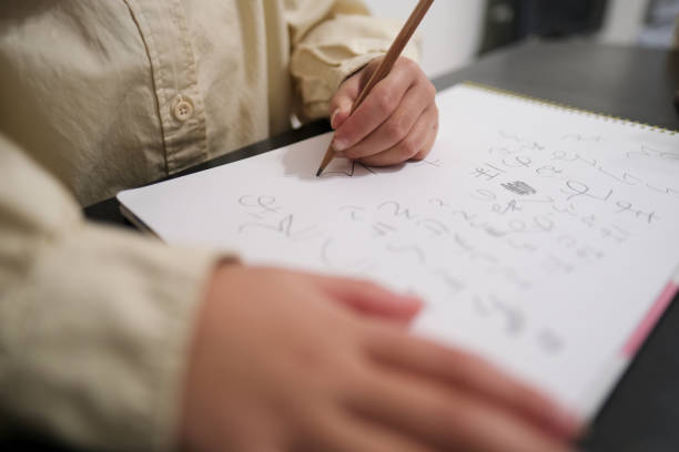 A student doing math in a notebook using a scientific calculator. Close up.