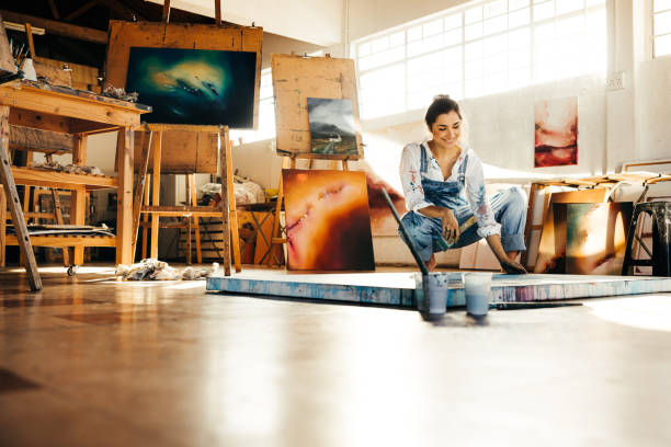 istock Happy female painter working on a new painting 1357660940