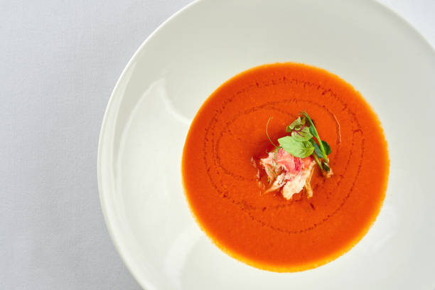 istock Cream soup from baked tomato with crab in a white plate on a white tablecloth 1357662140