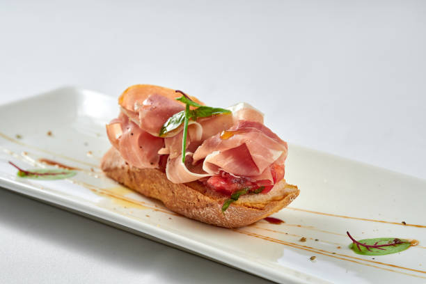 istock Bruschetta with prosciutto in a white plate on a white tablecloth 1357662209