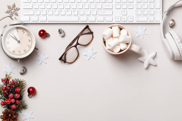 istock Christmas desktop. Keyboard glasses headphones marshmallow alarm clock on a gray table. Flat lay top view copy space 1357664144