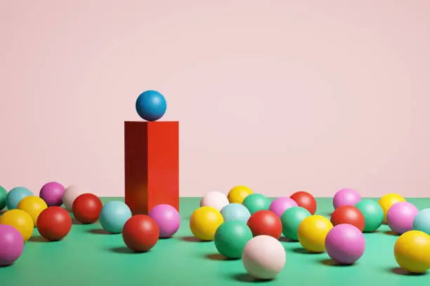 Blue plastic ball on red platform stands out from the crowd. Difference, champion, winner, diversity, individuality or leadership concept. 3d render.